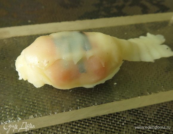 На рис с рыбой кладем кусочки кальмара, формируем из длинных полос хвост.