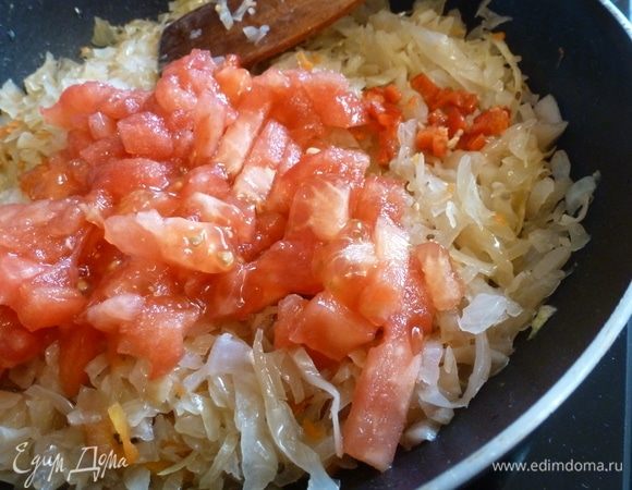 На сковороде поджарим нарезанный лук, затем добавим капусту, немного обжарим ее. С помидора снимем кожицу, нарежем кубиком и отправим к капусте. 
