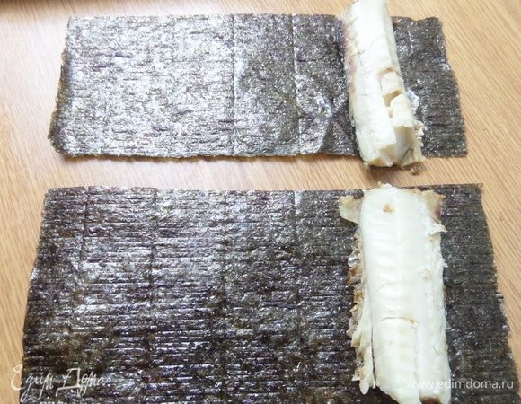 Второй лист нори делим пополам. Положить с краю филе хека.