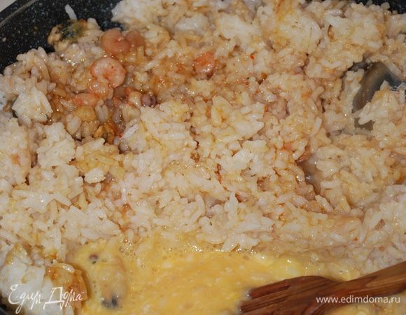 Рис отодвигаем, чтобы было место для яйца. Взбалтываем яйцо, дожидаемся, чтобы оно схватилось немного, и все перемешиваем, посыпаем зеленью.