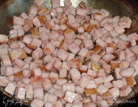 В сковороду наливаем 2 ст. л. растительного масла. Выкладываем нарезанное варено-копченое мясо и обжариваем 5-7 минут.