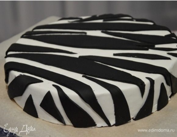 Ганаш застыл, можно покрывать мастикой. Этот вариант украшения очень простой: покрываем торт белой мастикой, а из черной вырезаем произвольные полосочки и выкладываем в произвольном порядке на торт.