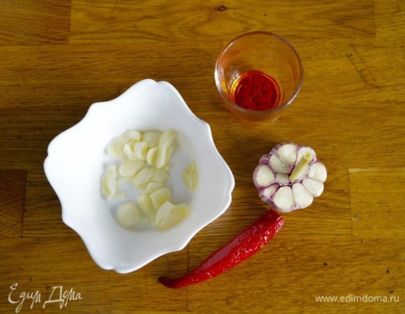 Половинку чеснока очистить и раздавить ножом. С целого чеснока снять верхний слой, срезать 1/3 головки, оставив стебель. У острого перчика срезать шляпку и вытряхнуть семена. Заварить шафран, залив его 1 столовой ложкой кипятка.