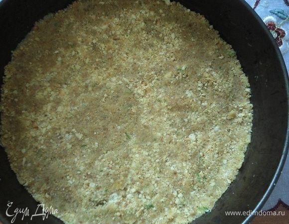 Получившуюся крошку распределить по форме 26 см, прижимая ложкой. Убрать в  морозилку на 10 минут.