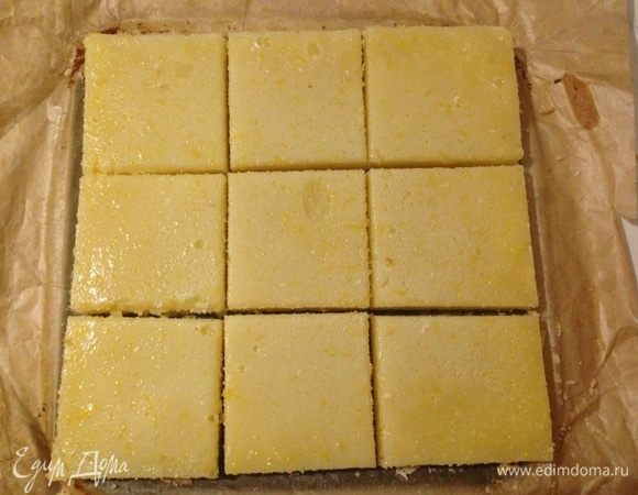 Вылить начинку на запеченную основу и снова отправить в духовку на 15-20 минут. Остудить готовый пирог в форме в течение часа при комнатной температуре, затем отправить в холодильник еще на 3 (и более) часа. Извлечь из формы, присыпать сахарной пудрой и по желанию цедрой, затем разрезать на порционные куски (на 9 частей).