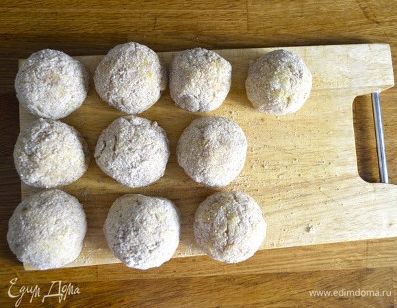 Достать заготовки для аранчини, придать им идеальную форму и еще раз обвалять в сухарях.