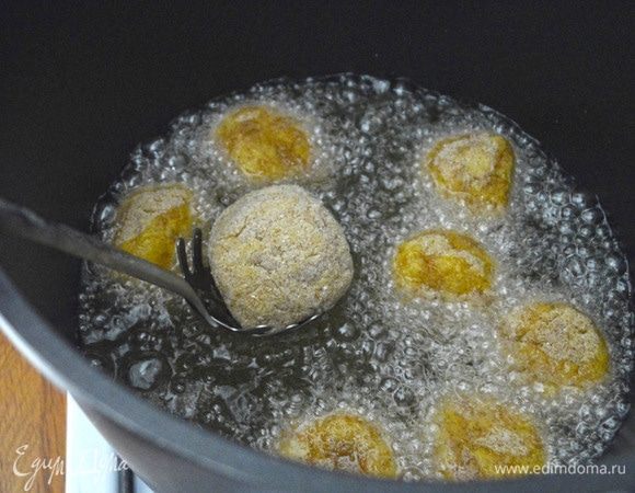 Аккуратно, избегая разбрызгиваний разогретого масла, опустить аранчини.