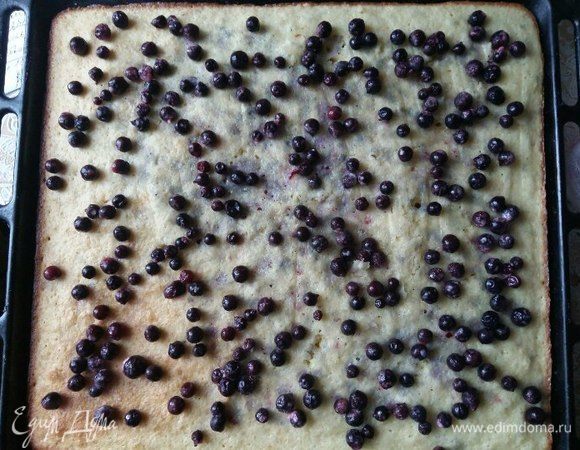 Прошло 15 минут, вынимаем из духовки пирог. Тесто сверху уже схватилось, что нам и нужно. Выкладываем ягоды по всей поверхности пирога.