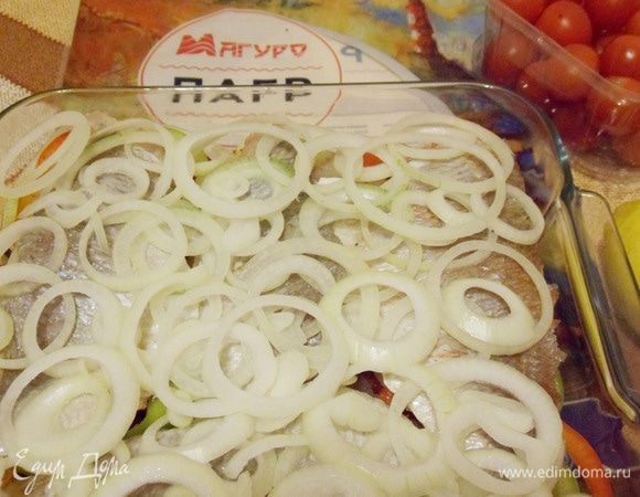 Филе пагра накрыть кольцами лука.