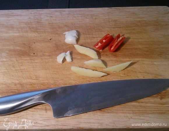Нарезаем половинку чили с той стороны где семена, крупно бруском имбирь, чеснок просто давим плоскостью ножа. Это все нам понадобиться для ароматизации масла.