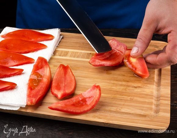 Приготовьте ароматные вяленые помидоры для закуски. Помидоры промойте, вырежьте плодоножку, разрежьте пополам и вычистите ложкой семена вместе с соком. Выложите на бумажные полотенца, чтобы убрать сок.