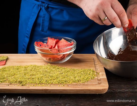 Молочный шоколад растопите на водяной бане, фисташки измельчите. Охлажденные чипсы полейте с одной стороны шоколадом.