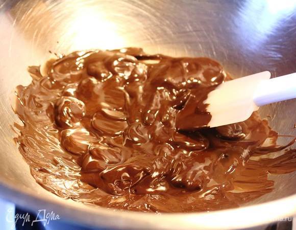 Организовываем водяную баню. В кастрюлю с кипящей водой ставим миску (чтоб она дном не касалась воды). Растопим шоколад. Добавим в него ванильную эссенцию. Ее можно заменить на ром, коньяк, ликер, кленовый сироп.