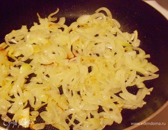 На сковороду налить не много растительного масла. Выложить репчатый лук и жарить до легкой золотистости (примерно 5–10 минут). Затем переложить рис на тарелку.