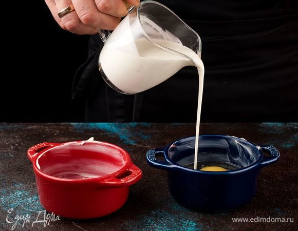 Сверху на яйца добавьте по 1 ст. л. сливок. Добавьте специи по вкусу. Запекайте яйца при 160°С 20 минут. 