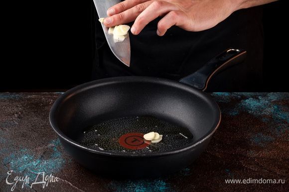 Чеснок порезать тонкими пластинками и прогреть на сковороде с маслом до легкого аромата.