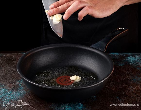 Чеснок порезать тонкими пластинками и прогреть на сковороде с маслом до легкого аромата.