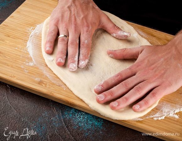 Когда тесто поднимется, вымесите его и растяните в лепешку толщиной 7 мм. Лучше тесто растянуть руками, а не раскатывать скалкой. 