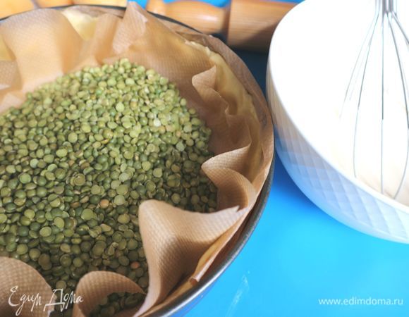 Духовку разогреть до 200°С. На тесто поместить бумагу для выпечки, горох (чечевицу, фасоль), отправить в духовку на 20 минут.