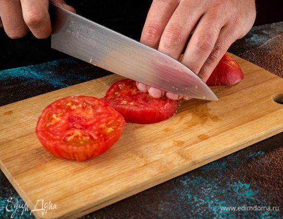 С помидора снять кожицу, нарезать его кусочками.
