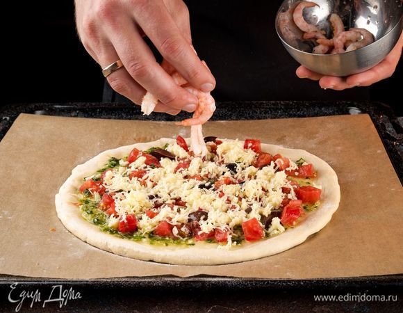 Креветки ТМ «Магуро» очистите и разложите сверху на тесто, посыпьте специями. Выпекайте пиццу 20 минут при 200°С.