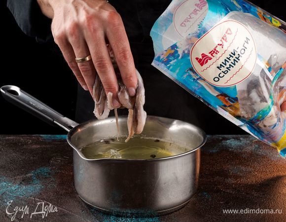 Налить в кастрюлю воды, добавить перец горошком, лавровый лист, одну очищенную луковицу. Довести воду до кипения. Разморозьте мини-осьминогов ТМ «Магуро» и положите в кипящую воду. Варите 15 минут до готовности. Готовых мини-осьминогов остудите в той воде, в которой они варились.