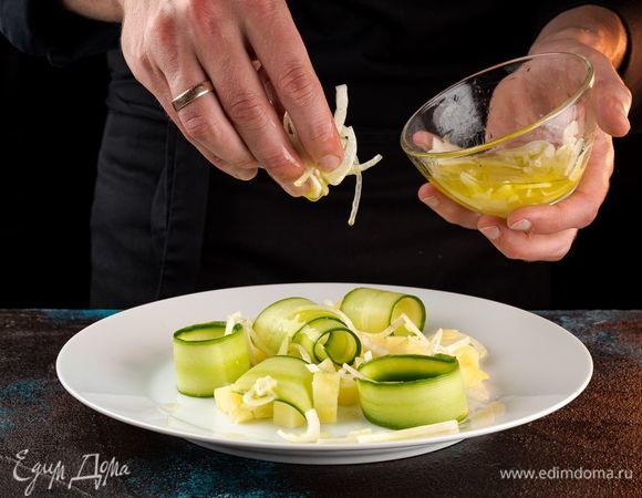 На широкую тарелку выложите картофель, сверху — огурцы, маринованный лук.