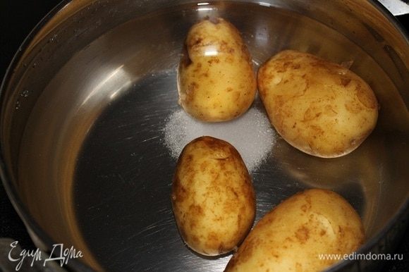 Картофель залить водой, добавить соль и варить после закипания 15 минут. Достать из кастрюли и остудить.