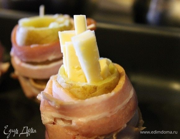 Заполнить сыром картофель. Выпекать в заранее разогретой до 200°С духовке, 20–30 минут.