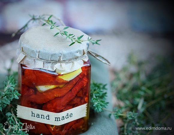 На дно горячей банки кладем чеснок, травы, базилик, часть помидор. Так чередуем слои, пока полностью не заполнится банка. Далее заливаем банку примерно на 3/4 обычным маслом и оставшуюся 1/4 — кипящим. Плотно закрыть крышкой. Хранить в холодильнике.