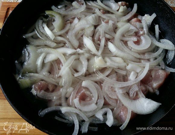 Выложим в сковороду мясо, сверху лук, зальем водой так, чтобы покрыло мясо полностью, поставим на огонь. Как закипит, снимем пену, убавим до минимума огонь, накроем крышкой и потушим до полного выкипания воды (примерно 1–1 ч 15 мин).
