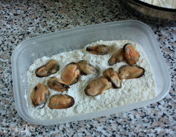 В глубокой сковороде нагреть масло. Мидии обсушить и частями обвалять сначала в муке, 
