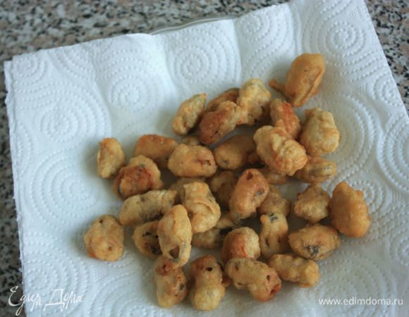 Шумовкой переложить готовые мидии на блюдо с бумажным полотенцем.