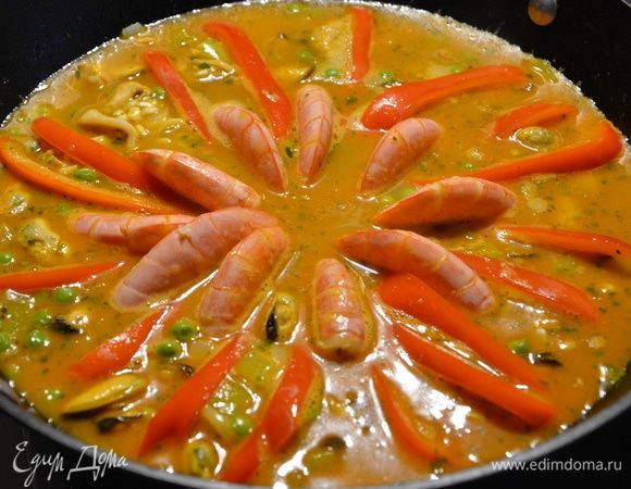 Сверху по кругу выложить красный болгарский перец и аргентинские креветки. Прикрыть крышкой и готовить до полного выпаривания жидкости.