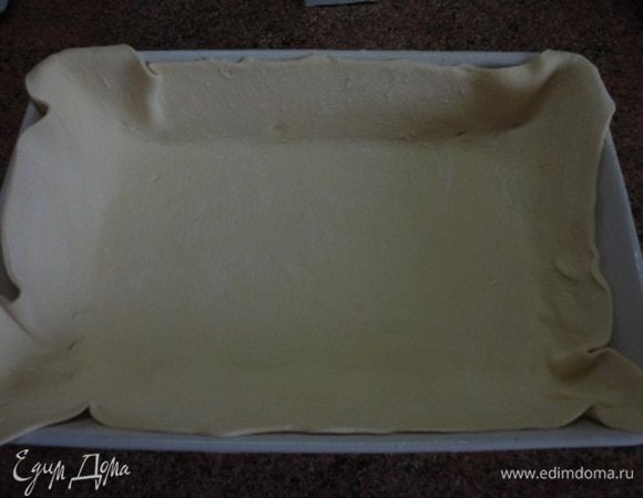 Форму смазать частью растопленного сливочного масла. Тесто тонко раскатать и выложить в форму, формируя бортики.