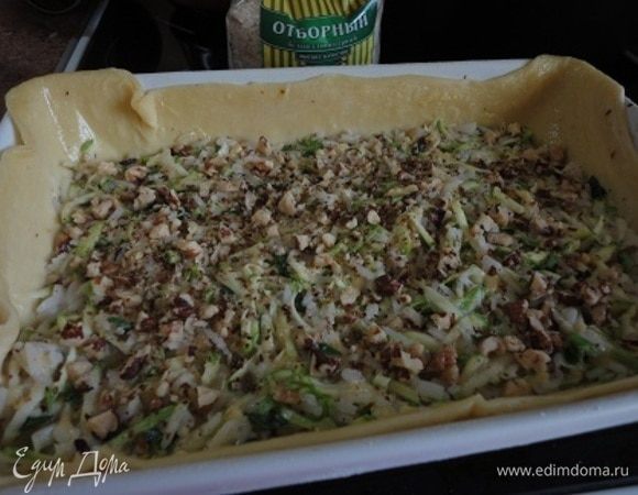 В центр тарта выложить начинку, посыпать второй половиной орехов, края теста смазать сливочным маслом. Выпекать 25 минут при температуре 180°С.