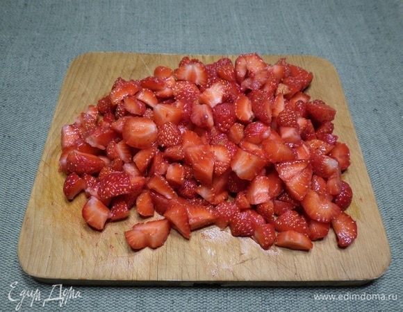 Немного клубники отложить для украшения торта, а оставшуюся нарезать.