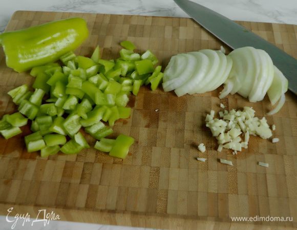 Лук нарезать полукольцами, перцы — средними кусочками, а чеснок порубить.
