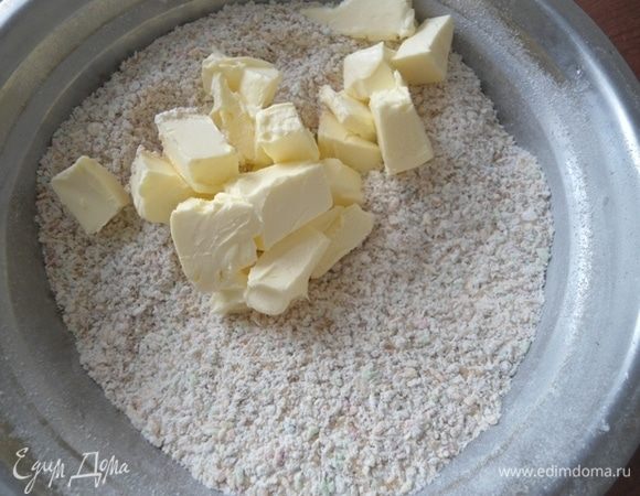Холодное сливочное масло нарезать кубиками, смешать с сухой смесью, чтоб получилась крупная крошка. Можно руками или порубить ножом.