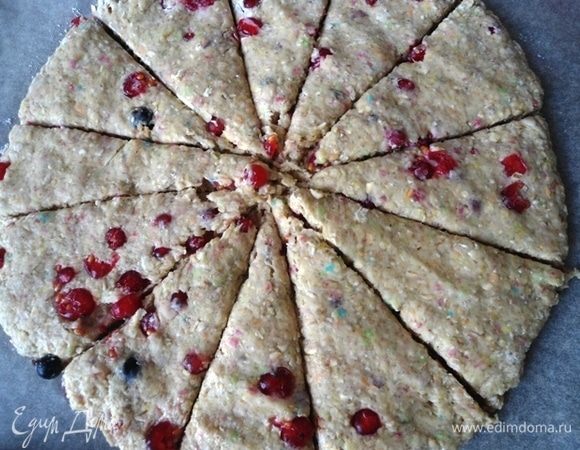 Добавить в тесто смородину. Тесто расплющить руками на присыпанной мукой доске и нарезать на сегменты. У меня получилось 12 штук.