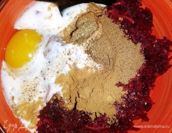 Натираем свежую свеклу на мелкой терке. Разбиваем одно яйцо. Добавляем сахар. Его у меня совсем немного, потому что свекла домашняя, очень сладкая. Наливаем ряженку. Чтобы вафли были пряными, используем специи. Перемешиваем.