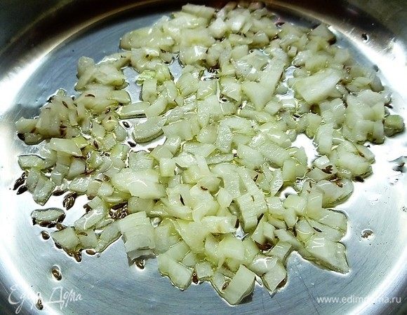 В сковороде с толстым дном разогреваем масло, обжариваем кумин в течение 1 минуты, добавляем лук и обжариваем его до легкого золотистого цвета.
