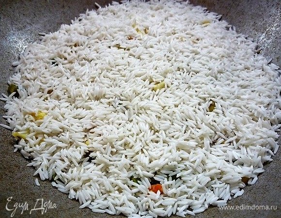 С риса сливаем воду. В казан выкладываем овощи, добавляем специи. Поверх овощей выкладываем рис. Заливаем водой так, чтобы она только покрывала рис. Ставим казан на слабый огонь на 35 минут. Готовим плов под крышкой, не перемешивая его.