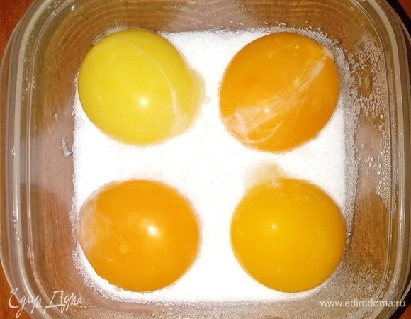 Засыпаем дно посуды слоем смеси из соли и сахара. Контейнер  выбираем из не окисляющегося материала. Аккуратно помещаем желтки в посуду на некотором расстоянии друг от друга. Затем полностью укрываем желтки смесью. 