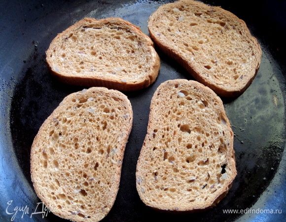 На сухую горячую сковороду положить ломтики хлеба с семечками.