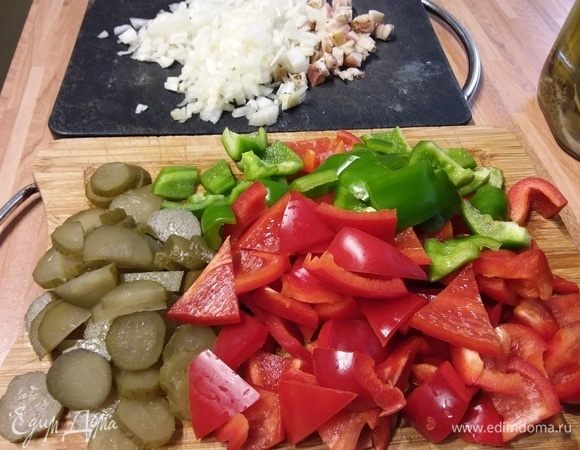 Лук и бекон мелко порубить. Перец очистить от семян и перепонок и нарезать с огурцами не слишком мелко. 