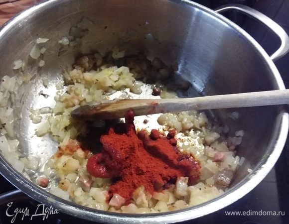 Добавить томат и порошок красной сладкой паприки, размешать и обжарить вместе еще несколько минут. Кто любит поострее, можно наряду со сладкой паприкой добавить щепотку порошка острой красной паприки по вкусу. 