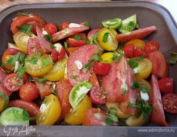 Помидоры помыть, разрезать на крупные дольки. Зелень помыть, снять с веточек. Чеснок очистить, порубить. Духовку разогреть до 180°С. Форму смазать оливковым маслом. Выложить в форму помидоры, полить оливковым маслом, бальзамическим уксусом (светлым), лимонным соком и медом. Посыпать чесноком, травами, солью и перцем. 