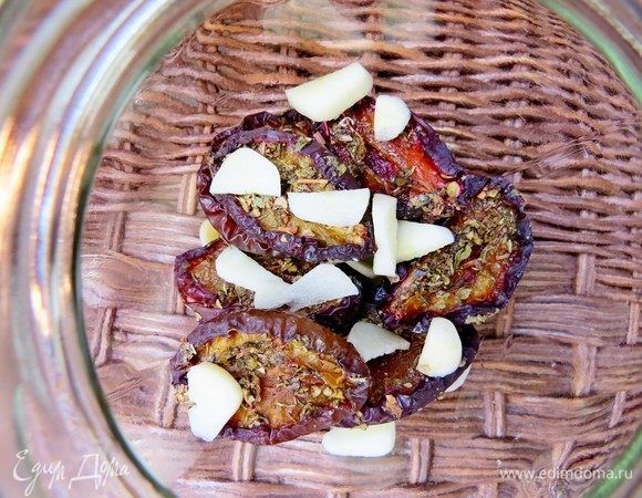 В чистую банку выкладываем слоями вяленые сливы, каждый слой присыпаем ломтиками чеснока.