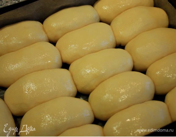 Выкладывать нужно близко друг к другу, чтобы боками соприкасались. Заполненный противень накрыть влажным полотенцем и оставить пирожки на расстойку на 30 минут. Пирожков получается на 2 противня, поэтому, пока одни подходят, делаем на второй противень. Выпекать их лучше по одному, но это в моей духовке. Взбить в миске яйцо, кистью смазать пирожки и поставить противень в духовку.